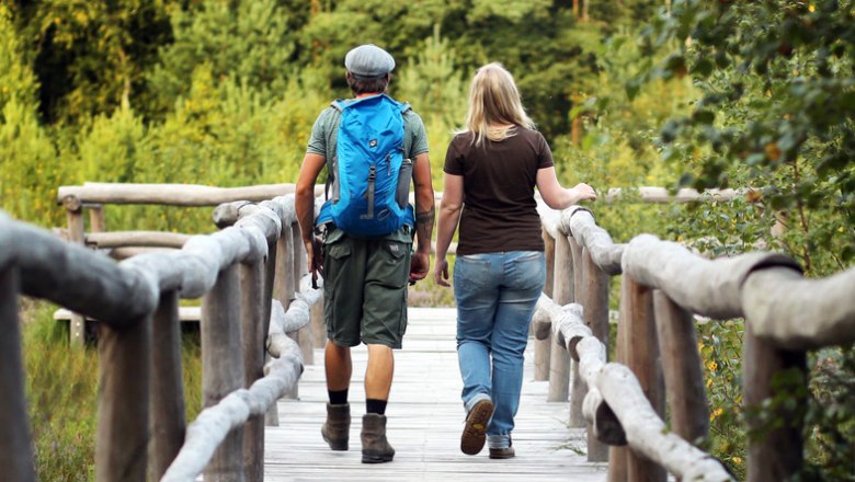 zwei Wanderer gehen über eine Brücke