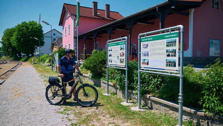 Fahrradfahrer erkundigt sich über die Waldviertelbahn auf einer Schautafel