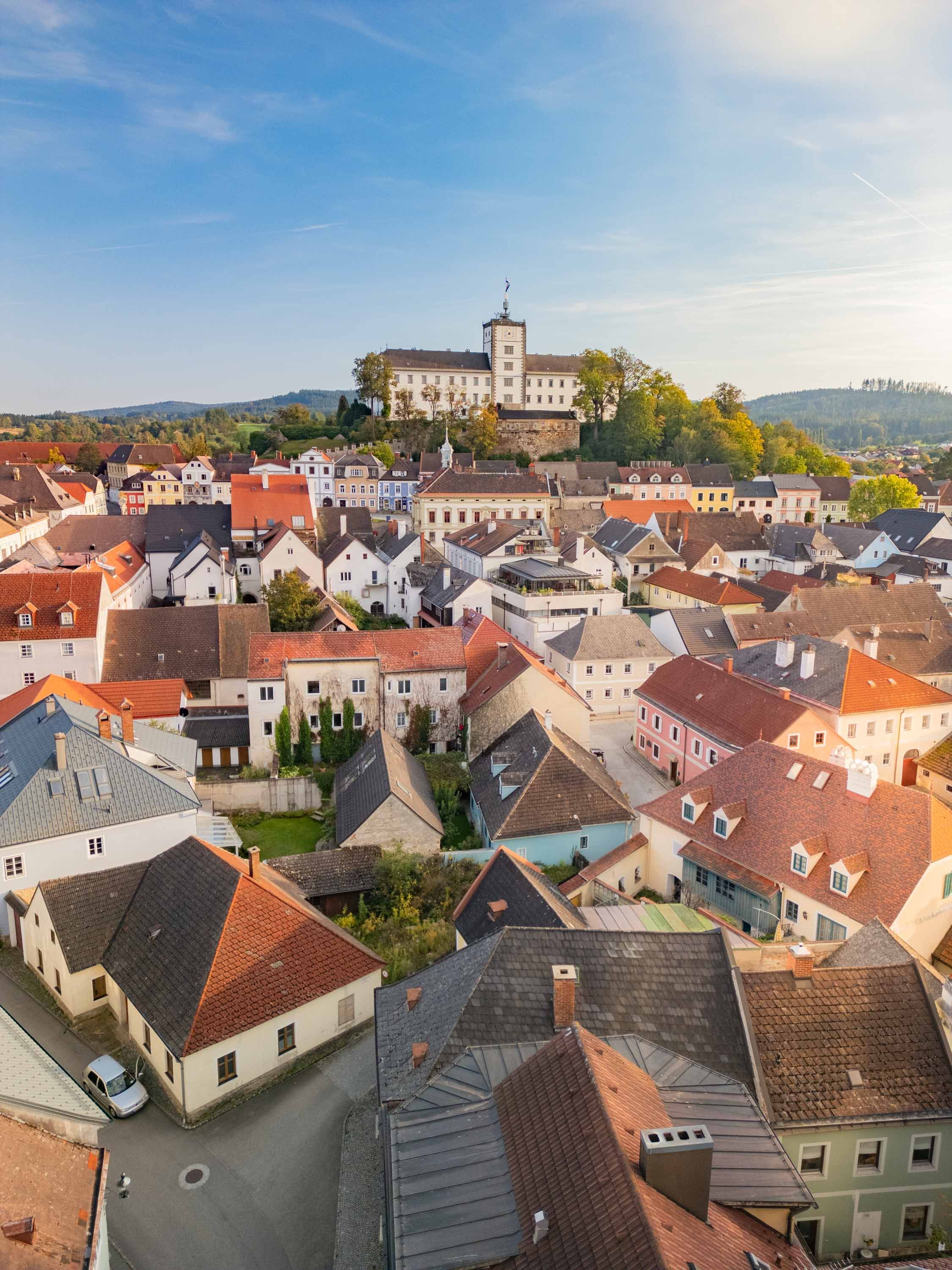 Luftaufnahme der Stadt Weitra mit Schloss im Hintergrund.