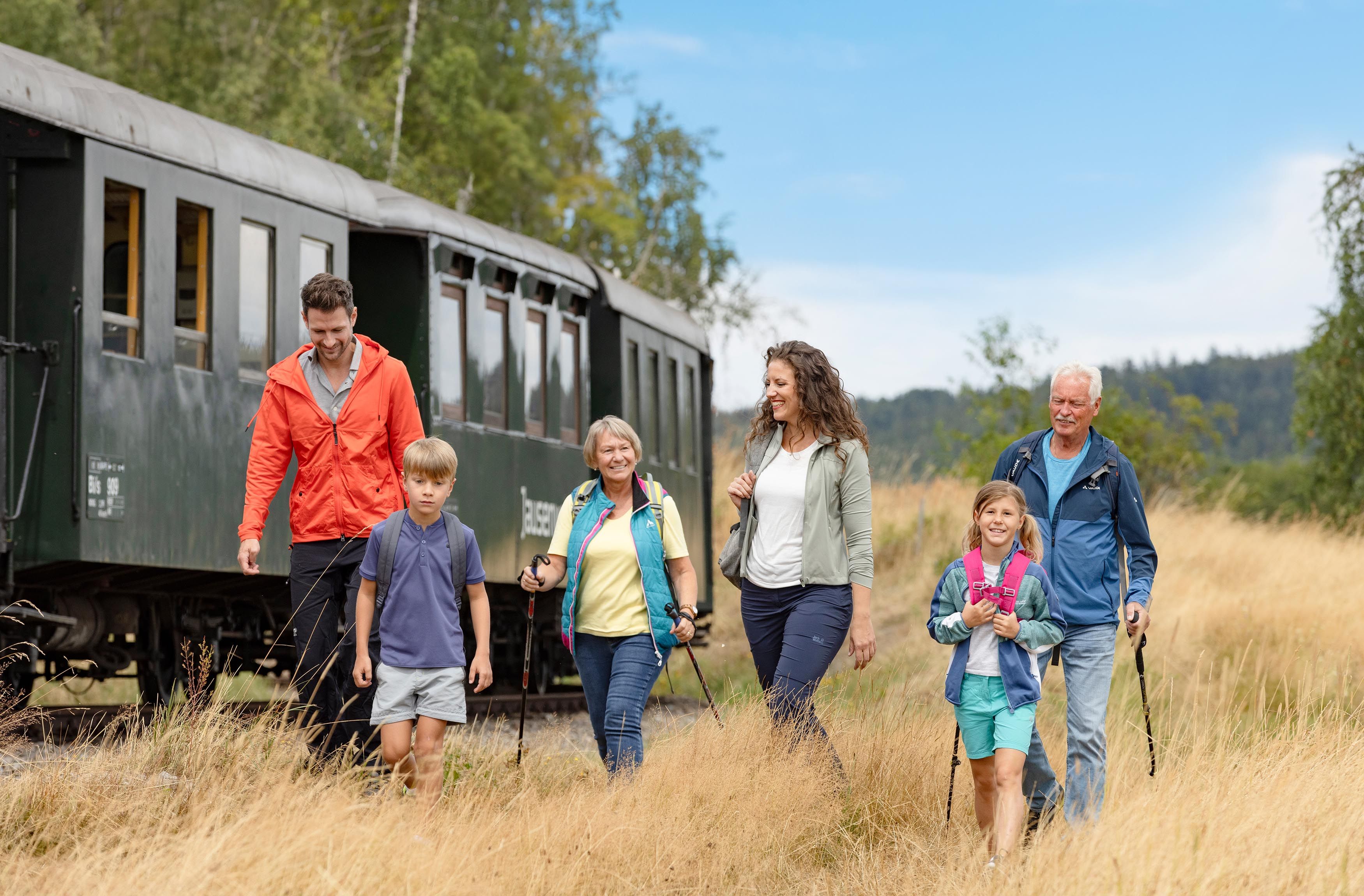 Familie spaziert neben dem Zug der Waldviertelbahn