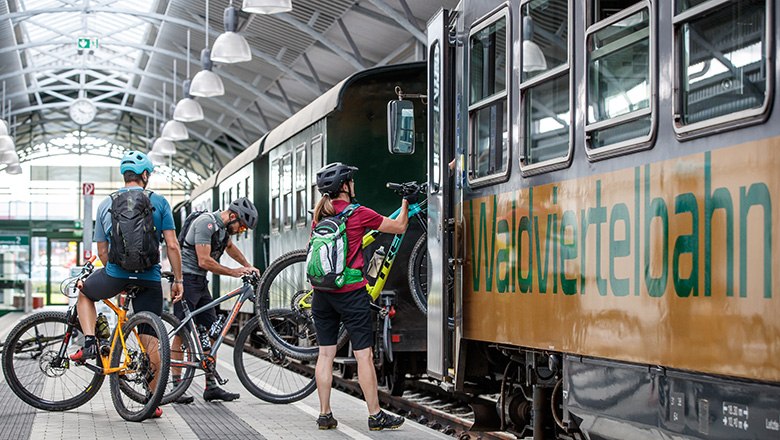 Radfahrer laden ihr Fahrrad in den Zug ein