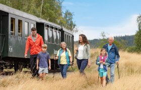 Familie spaziert neben dem Zug der Waldviertelbahn