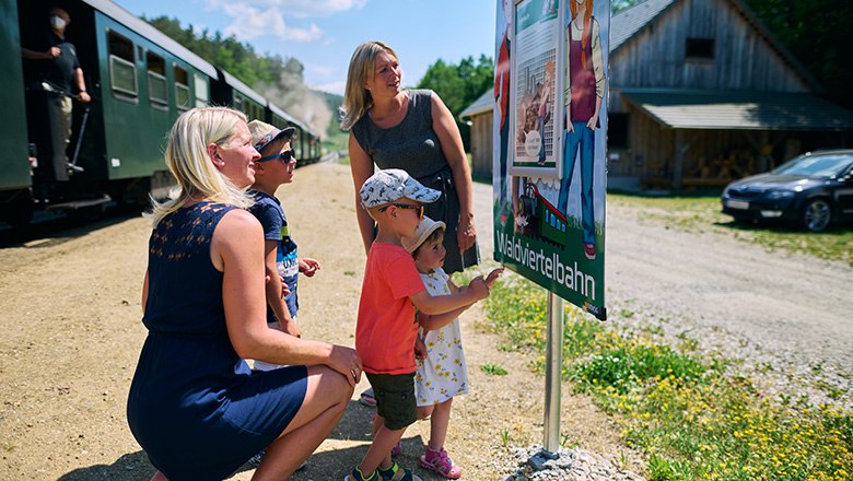 Familie erkundigt sich bei Schautafel