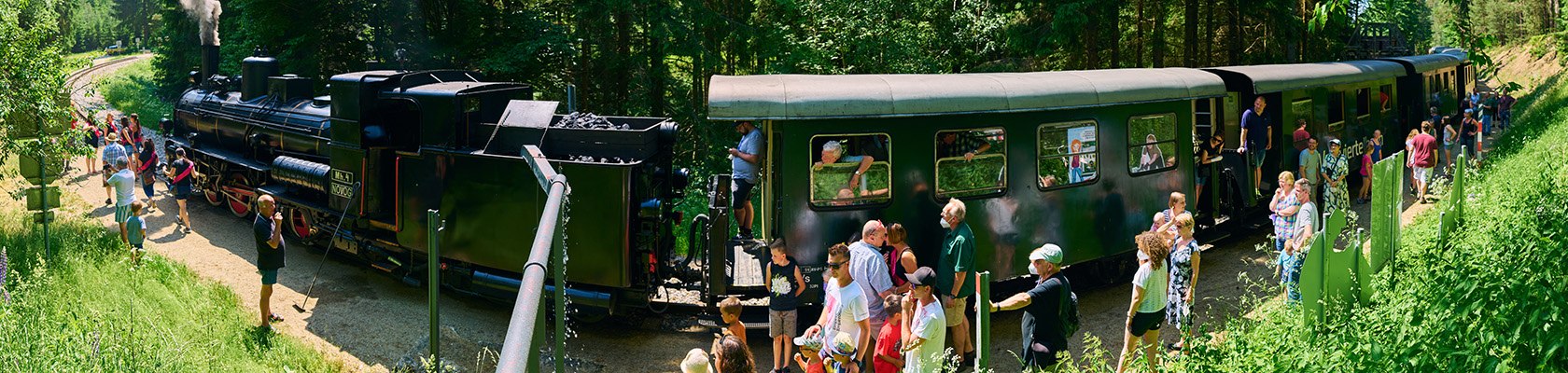 Gruppe an Menschen steigt aus der nostalgischen Dampflok aus