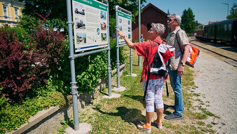 Mann und Frau erkundigen sich bei einer Schautafel